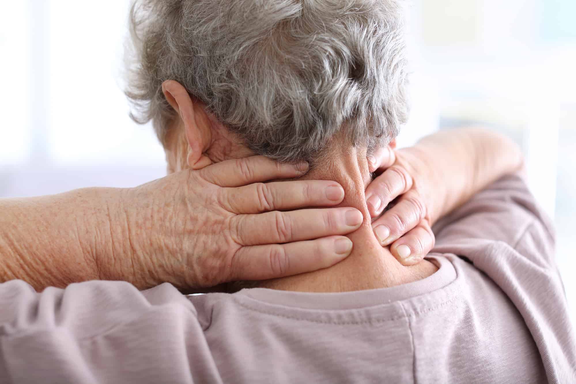 neck pain doctor Aventura, FL with an elderly woman suffering from neck pain